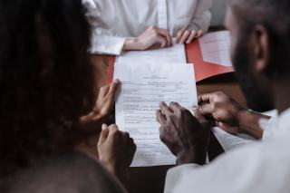 Title documents reviewed before a US property closing Property deed and closing documents laid out on a table before signing